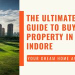 An image featuring a backdrop of buildings against a lush green landscape, overlaid with text reading 'The Ultimate Guide to Buying Property in Indore'